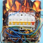 High-voltage electrical circuit breaker with wires and flames for safety testing.