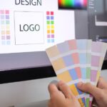 A person selecting colour swatches for graphic design on a computer screen.