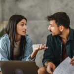 A woman and man having a discussion in a modern living room setting.