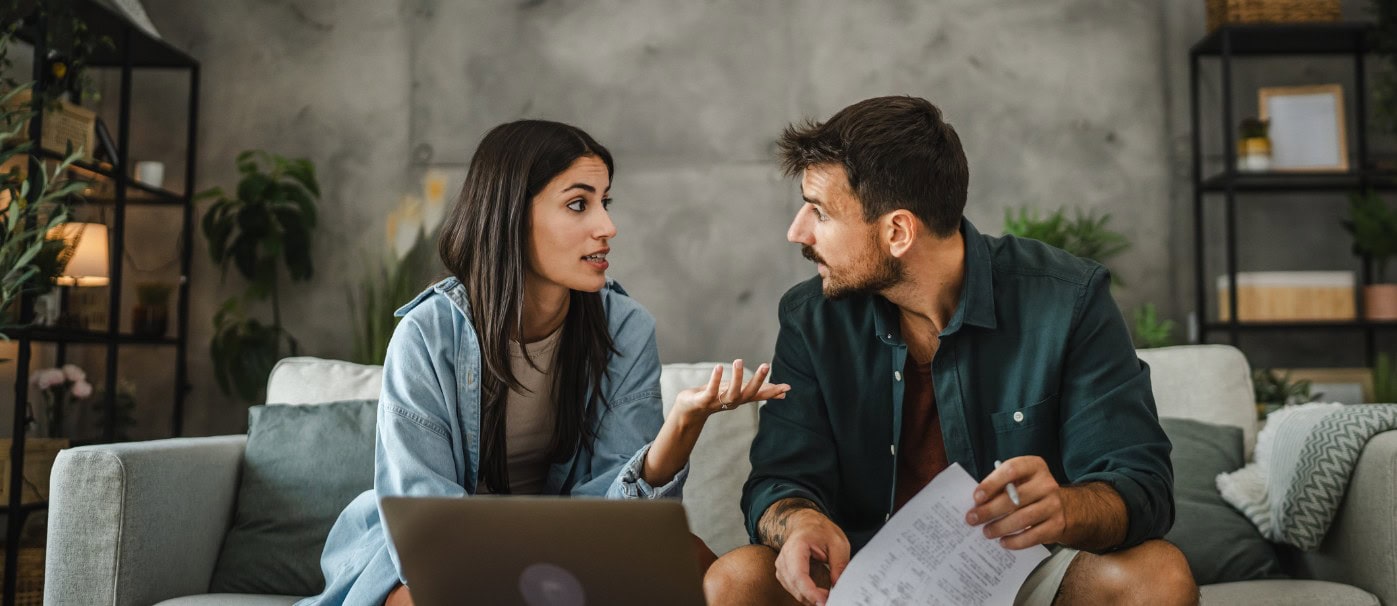 A woman and man having a discussion in a modern living room setting.