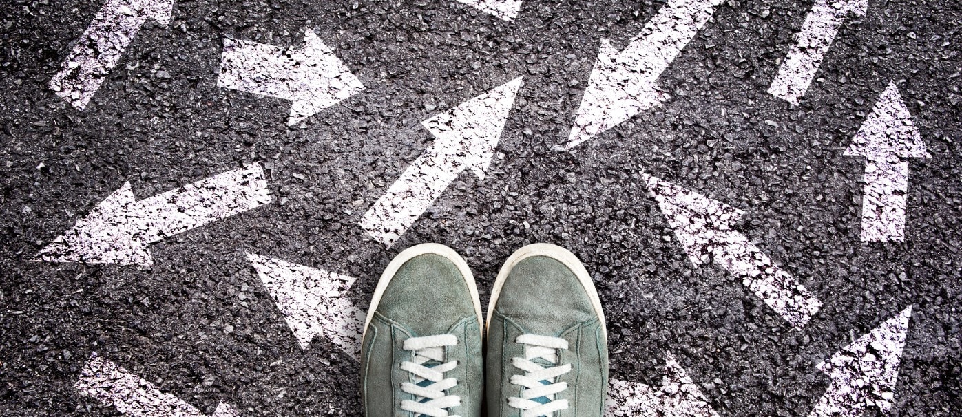 A woman standing on a chalk-drawn arrow parking lot with sneakers.