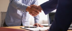 Professional handshake between two businesspeople in an office setting, symbolising partnership and.
